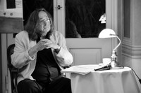 czesław gałużny siedzący przy stoliku podczas recytowania poezji