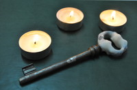 na zdjęciu widnieją dwie świeczki i klucz