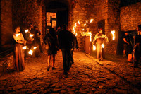 kobiety trzymające pochodnie przed wejściem do zamku, noc